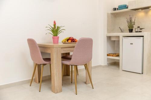 a dining room table with two chairs and a bowl of fruit at Katerina Roza Studios - Heartfelt Hospitality in the City in Naxos Chora