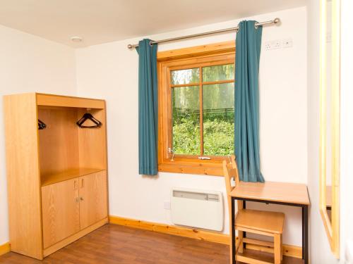 a room with a desk and a window at YHA London Lee Valley in Cheshunt