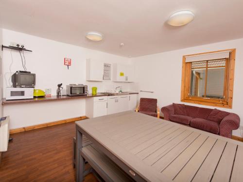 a kitchen and living room with a table and a couch at YHA London Lee Valley in Cheshunt