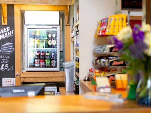 a room with a refrigerator with drinks in it at YHA London Lee Valley in Cheshunt