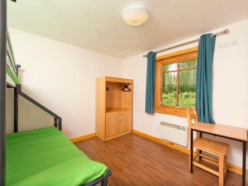 a bedroom with a bed and a desk and a window at YHA London Lee Valley in Cheshunt