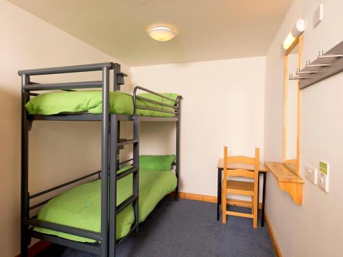 a room with two bunk beds and a table at YHA London Lee Valley in Cheshunt