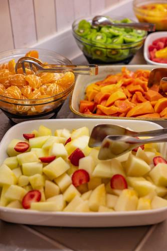 a table topped with three trays of fruit and vegetables at Corallium Beach by Lopesan Hotels - Adults Only in San Agustin