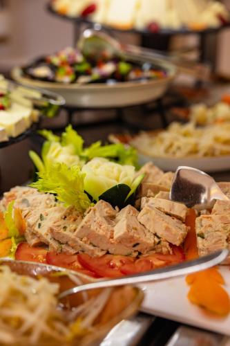 a plate of food with meat and vegetables on a table at Corallium Beach by Lopesan Hotels - Adults Only in San Agustin