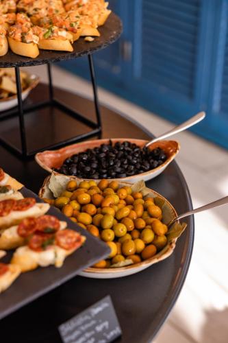 a tray of food on a table with plates of food at Corallium Beach by Lopesan Hotels - Adults Only in San Agustin