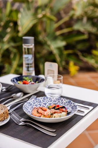 a table with a plate of food on a table at Corallium Beach by Lopesan Hotels - Adults Only in San Agustin