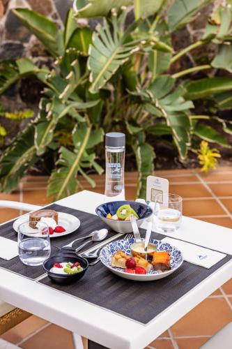 a table with plates of food on top of it at Corallium Beach by Lopesan Hotels - Adults Only in San Agustin