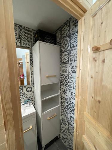 Elle comprend une petite salle de bains pourvue d'un réfrigérateur blanc et d'un évier. dans l'établissement Studio Cosy Saint-Véran, à Saint-Véran