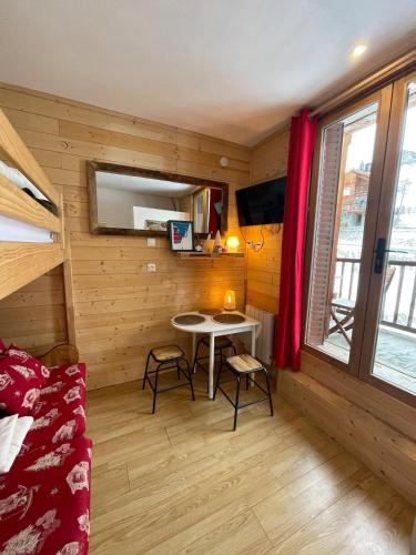 Cette petite chambre comprend une table et un canapé. dans l'établissement Studio Cosy Saint-Véran, à Saint-Véran