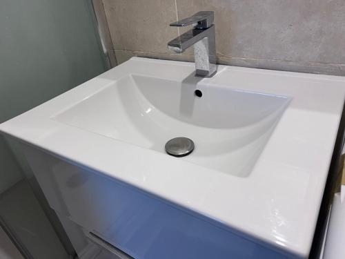 - un lavabo blanc avec un robinet en argent dans l'établissement Paris Saint-Paul, à Paris