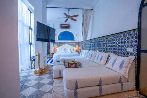 a hotel room with two beds and a couch at Maison H Kasbah in Marrakech