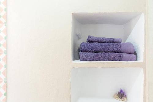 ein paar lila Handtücher in einem weißen Regal in der Unterkunft LOFT IN VaLLEY RODALQUILAR in Rodalquilar