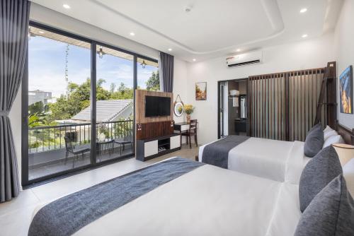 a bedroom with two beds and a large window at Champion villa Hoi An in An Bang