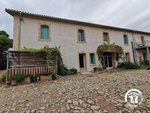 a house with a stone driveway in front of it at Domaine de Stony - Eco-Gîtes et Vignoble in La Peyrade
