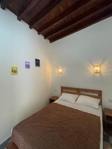 - une chambre avec un lit et deux lumières sur le mur dans l'établissement Dar MIMA, à Rabat