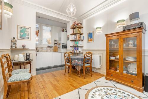 une cuisine et une salle à manger avec une table et des chaises dans l'établissement Refurbished Haussmannian apartment, à Paris