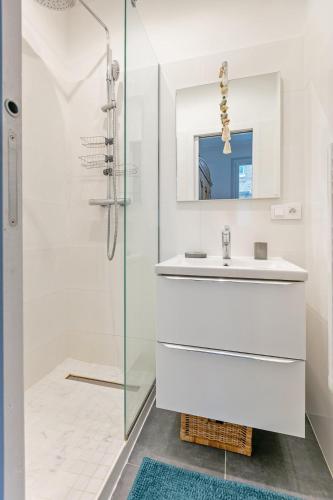 une salle de bain blanche avec un lavabo et une douche dans l'établissement Refurbished Haussmannian apartment, à Paris