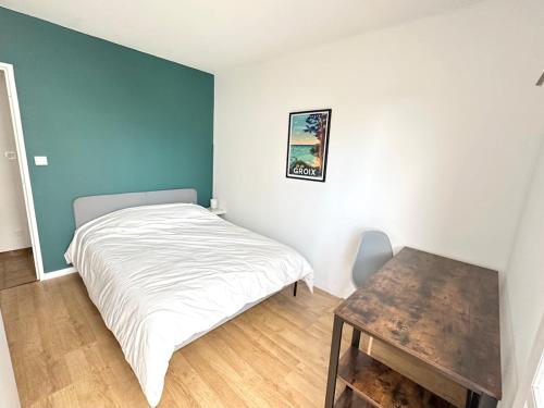 une petite chambre avec un lit et une table dans l'établissement Le carré Dijonnais - Spacious & parking included, à Dijon