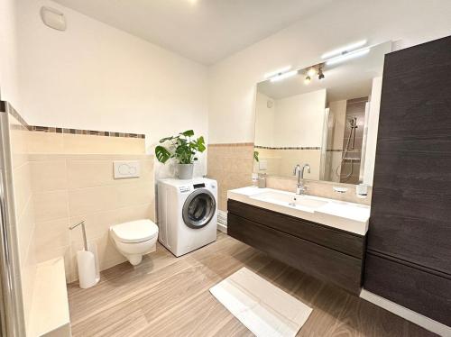 une salle de bain avec une machine à laver et un lavabo dans l'établissement Le carré Dijonnais - Spacious & parking included, à Dijon