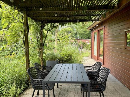 a wooden table and chairs on a patio at Tiny Lodge Basic in Harderwijk