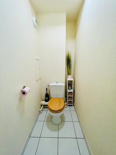 La salle de bains est pourvue de toilettes et d'un siège en bois. dans l'établissement Stylish apartment a stone's throw from Disneyland Paris, à Serris