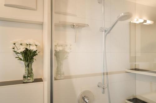 a bathroom with a shower with a vase of flowers at Neubau Stuttgart Messe Airport in Leinfelden-Echterdingen