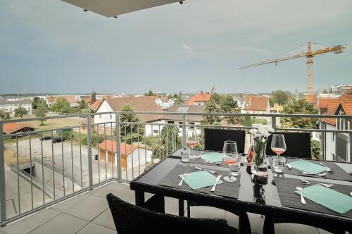 a table with wine glasses on a balcony at Neubau Stuttgart Messe Airport in Leinfelden-Echterdingen