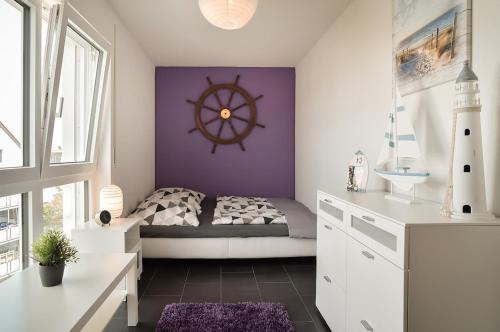 a bedroom with a bed with a nautical wheel on the wall at Neubau Stuttgart Messe Airport in Leinfelden-Echterdingen