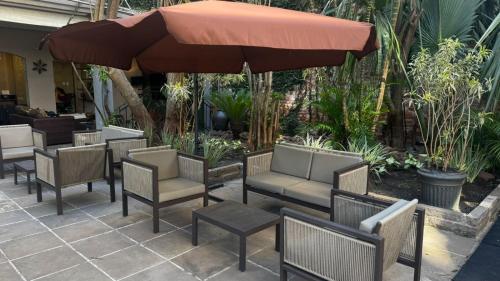a group of chairs and an umbrella on a patio at Ritter Hotéis in Porto Alegre