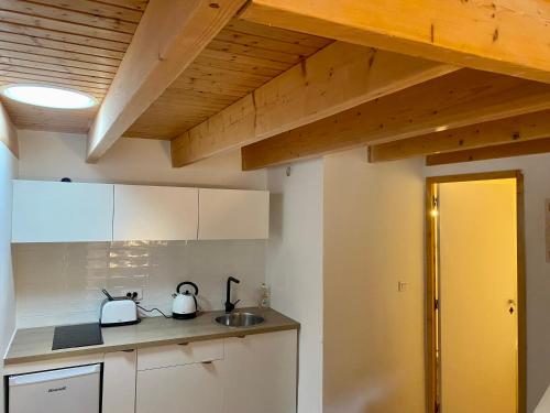 une cuisine avec des armoires blanches et un évier dans l'établissement Joli duplex en montagne, à Risoul