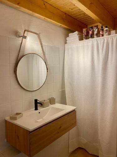 une salle de bain avec un lavabo et un miroir dans l'établissement Joli duplex en montagne, à Risoul