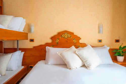two beds in a room with white pillows at Hotel Tiffany's in Roccaraso