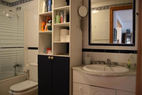 un bagno con lavandino, WC e specchio di Preciosa casa con terraza y piscina R64 by Novadesta a Gran Alacant