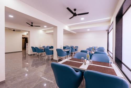 a banquet hall with blue chairs and a long table at Treebo Iris Executive, Hinjewadi in Pune