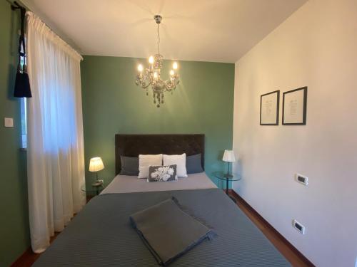 a bedroom with a large bed and a chandelier at Apartment Maximilian in Merano