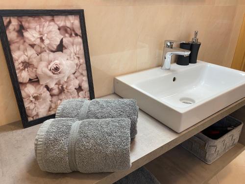 a bathroom with a sink and a stool next to a mirror at Apartment Maximilian in Merano