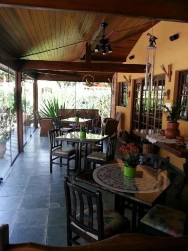 a restaurant with tables and chairs and a patio at Pousada Muriqui in São Francisco Xavier