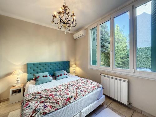 - une chambre avec un lit doté d'une tête de lit bleue et de fenêtres dans l'établissement 3-Bedroom house with terrace 5 minutes walking from La Croisette, à Cannes