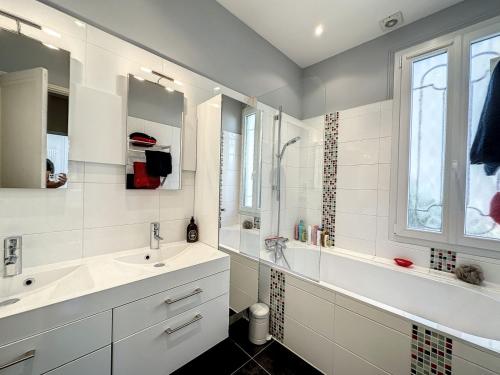 une salle de bain blanche avec deux lavabos et une fenêtre dans l'établissement 3-Bedroom house with terrace 5 minutes walking from La Croisette, à Cannes