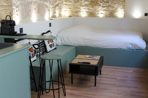 une chambre avec un lit et une table avec un tabouret dans l'établissement TheStudioFamily, à Dijon