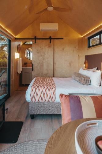 a bedroom with a large bed and a table at Stellenbosch Farm Cabin - Klein Frans in Stellenbosch