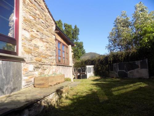 a stone house with a window and a yard at Cabaña Bioxana in Molejón
