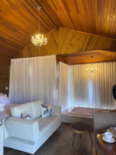 a living room with a couch and a table at Pousada Alto Colina - Chalé Quero-quero in Venda Nova do Imigrante