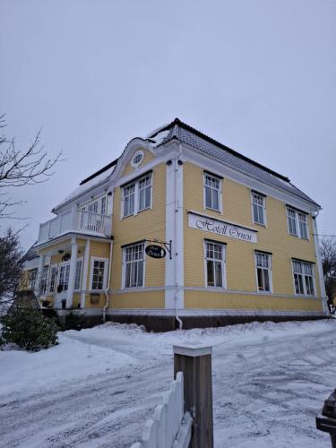 a large yellow building with snow on the ground at Hotell Örnen in Torsby