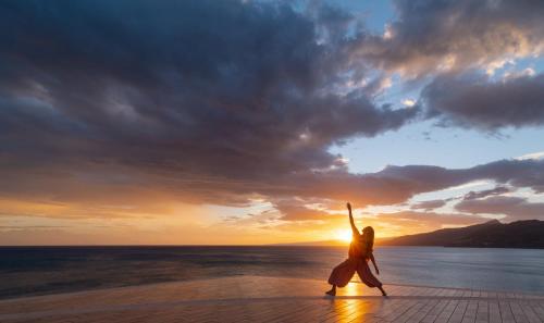 a person dancing on the beach at sunset at Hotel Kalura in Cefalù