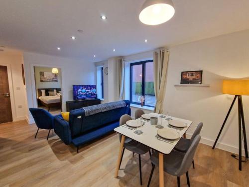 a living room with a table and a blue couch at Free Parking. Old Trafford Home in Manchester