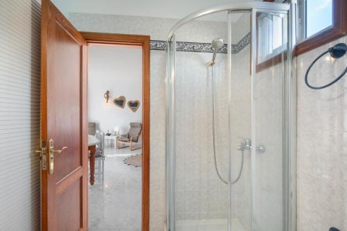 une salle de bain avec une douche avec une porte vitrée dans l'établissement Viento de Sal, à Mazo