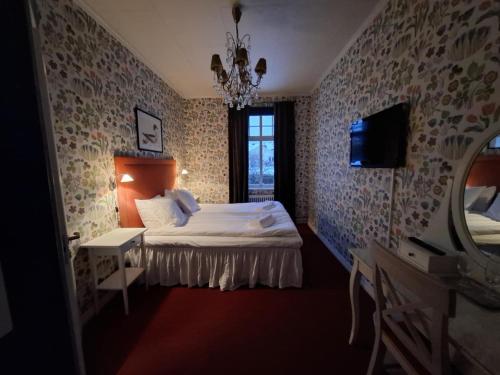 a bedroom with a bed and a tv and a window at Hotell Örnen in Torsby