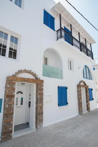 a white building with a door and a balcony at Studios Alsos in Naxos Chora