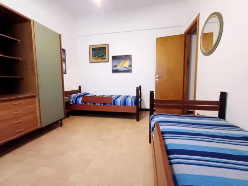 a bedroom with two beds and a dresser in it at Diana Cosy Apartment sea view near the beach in Monterosso al Mare